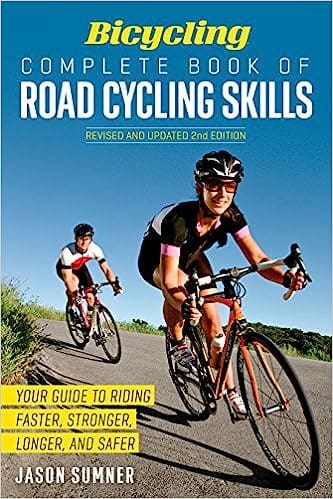 Cover image of Bicycling Complete Book of Road Cycling Skills, showcasing a cyclist in action on a winding road surrounded by lush greenery.