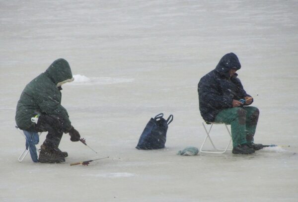 Ice fishing setup at Sylvan Lake Alberta with frozen lake and winter landscape.